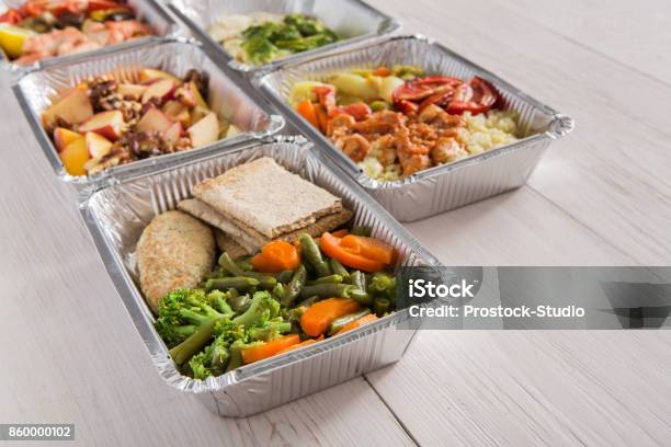 Healthy Food Take Away In Foil Boxes On Wood Background Stock Photo - Download Image Now