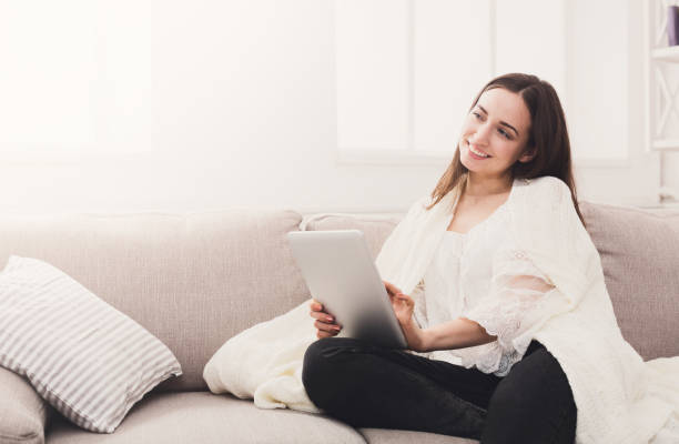 istock Cozy home. Girl in a plaid with a tablet 860003436