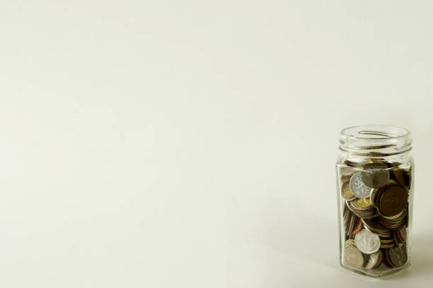 istock A glass bottle filled with coins. 860008558
