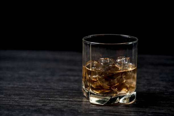 istock Glass of whiskey with ice on black stone table. 860012068