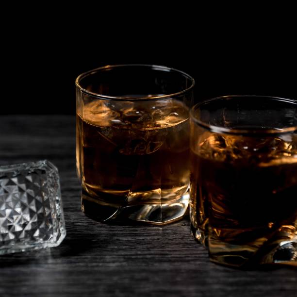 istock Glass of whiskey with ice on black stone table. 860012172