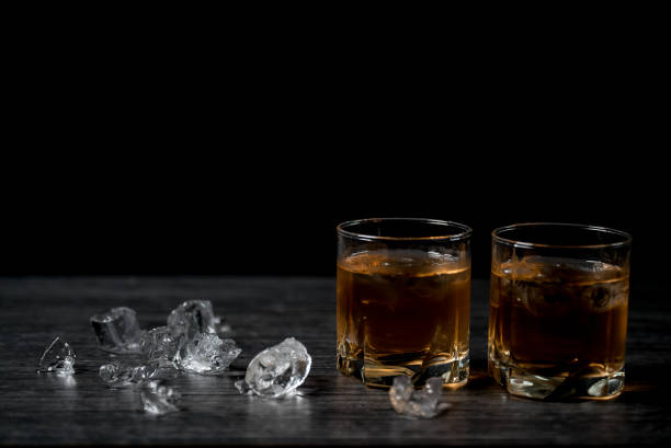 istock Glass of whiskey with ice on black stone table. 860012270