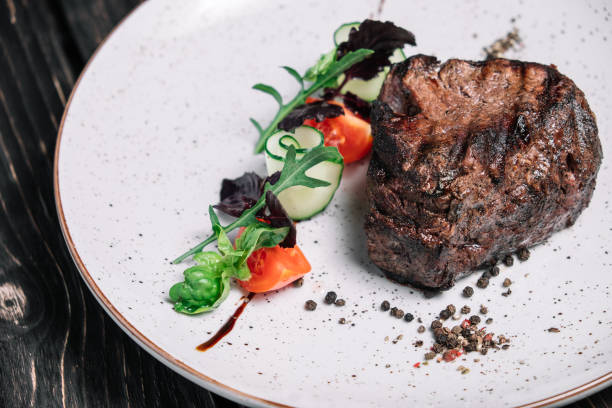 istock Grilled beef steak with salad on dark wooden background 860013414