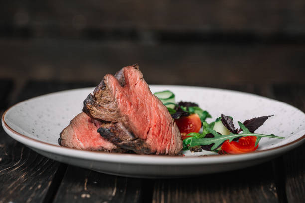 istock Grilled beef steak with salad on dark wooden background 860013724