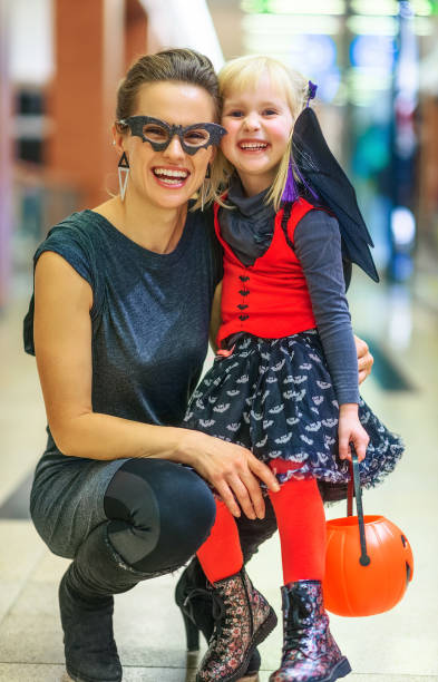 istock happy modern mother and child on Halloween at mall 860020902