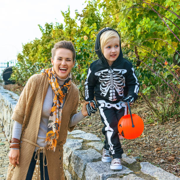 istock smiling modern mother and daughter on Halloween at park playing 860020942