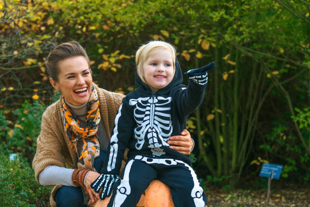 istock mother and daughter on Halloween at park pointing at something 860021040