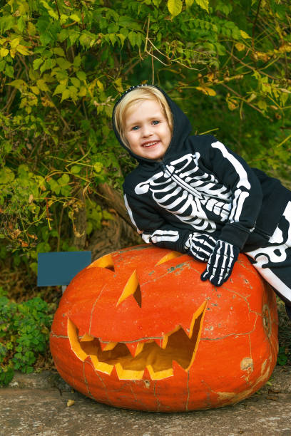 istock smiling girl with huge Halloween pumpkin Jack O
