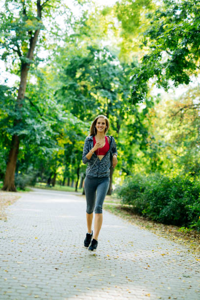istock Young blonde woman jogging in park 860024150