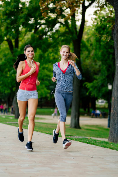 istock Two women jogging in park 860024428