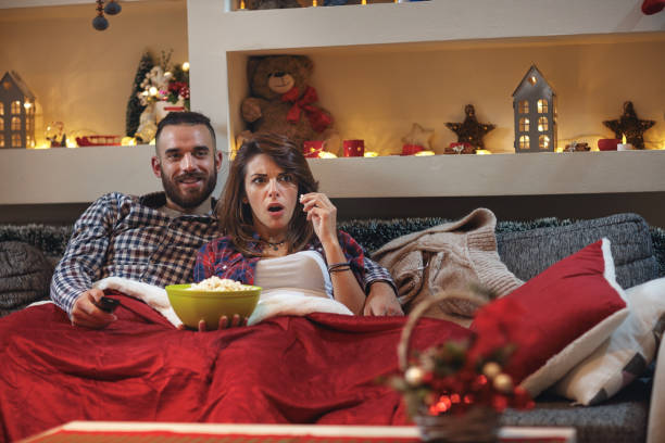 istock Girlfriend with boyfriend together in bad watching tv 860024770