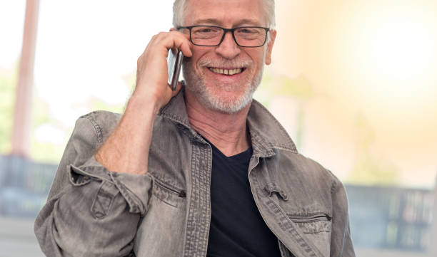 istock Portrait of smiling mature man talking on phone, light effect 860024916