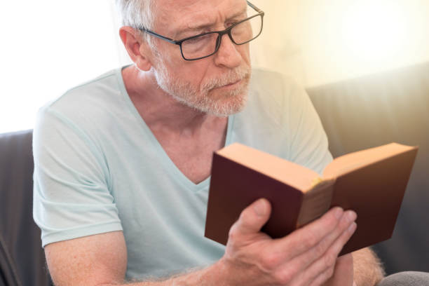 istock Portrait of mature man reading a book, light effect 860025134