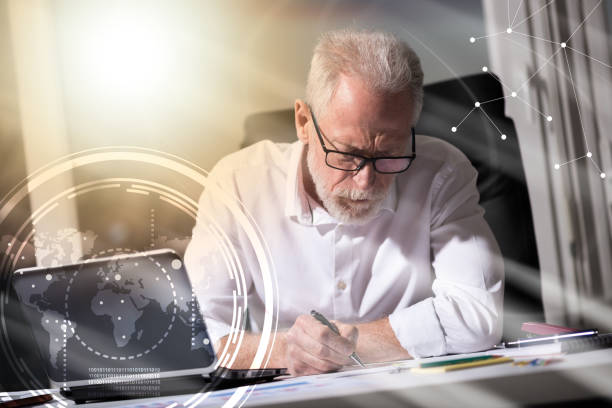 istock Senior businessman taking notes in office, light effect, light effect, overlayed with diagrams 860025666