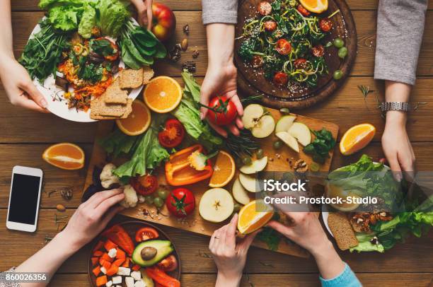 Photo libre de droit de Table À Dîner Femmes Mangent Des Aliments Sains À La Cuisine À Domicile banque d'images et plus d'images libres de droit de Cours de cuisine