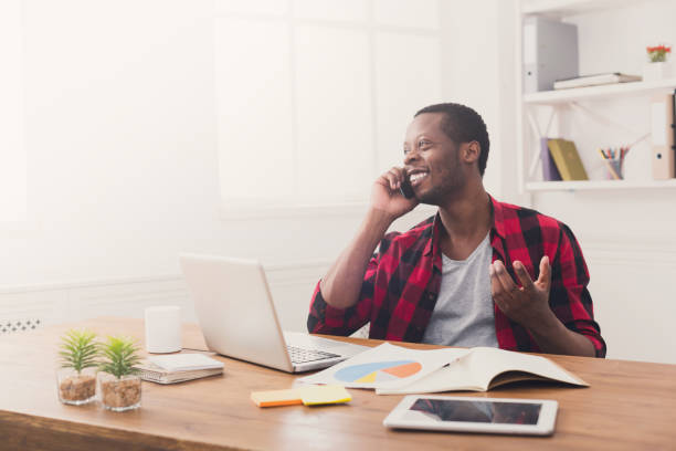 istock Young black businessman call mobile phone in modern white office 860026482