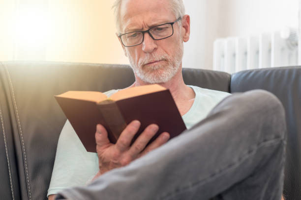 istock Portrait of mature man reading a book, light effect 860026788