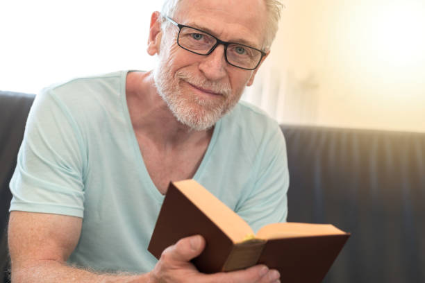 istock Portrait of mature man reading a book, light effect 860033082