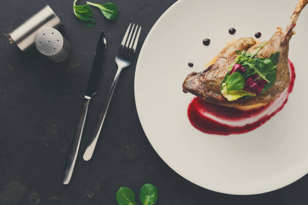 istock Restaurant meals. Duck confit with vegetables on black backgroun 860033308