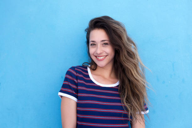 istock beautiful young woman smiling against blue background 860035454
