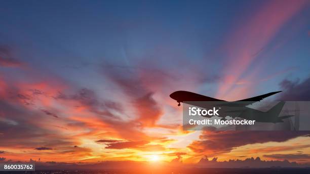 Foto de A Silhueta De Um Avião De Passageiros Voando No Pôr Do Sol e mais fotos de stock de Avião