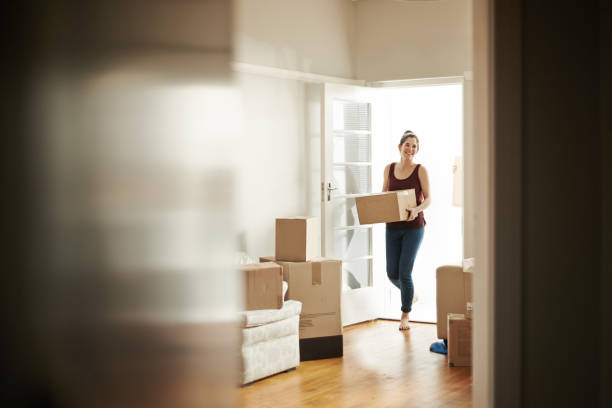 I bought the house of my dreams Shot of a woman carrying boxes into her new place belongings photos stock pictures, royalty-free photos & images