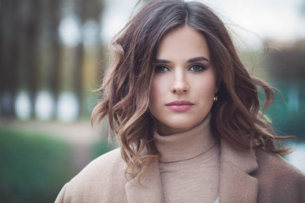 modelo de mulher bonita com cabelo encaracolado de sopro. menina bonito ao ar livre - women autumn teenage girls teenager - fotografias e filmes do acervo