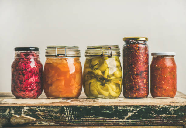 istock Autumn pickled colorful vegetables in jars placed in row 860048492
