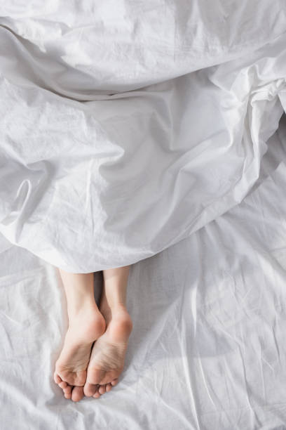 istock female feet stretching out of blanket 860048736