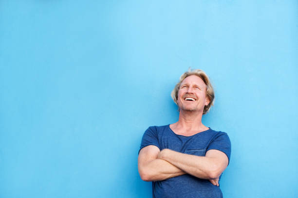istock smiling man standing with arms crossed and looking up 860049030