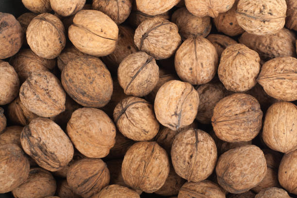 istock Scattered pile of walnuts, background, fresh, walnuts, market. Top view 860049854