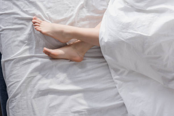 istock female feet stretching out of blanket 860053982