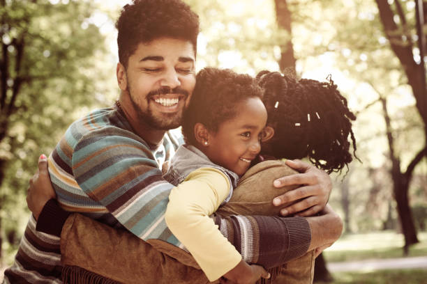 istock African American family hugging in park. 860066092
