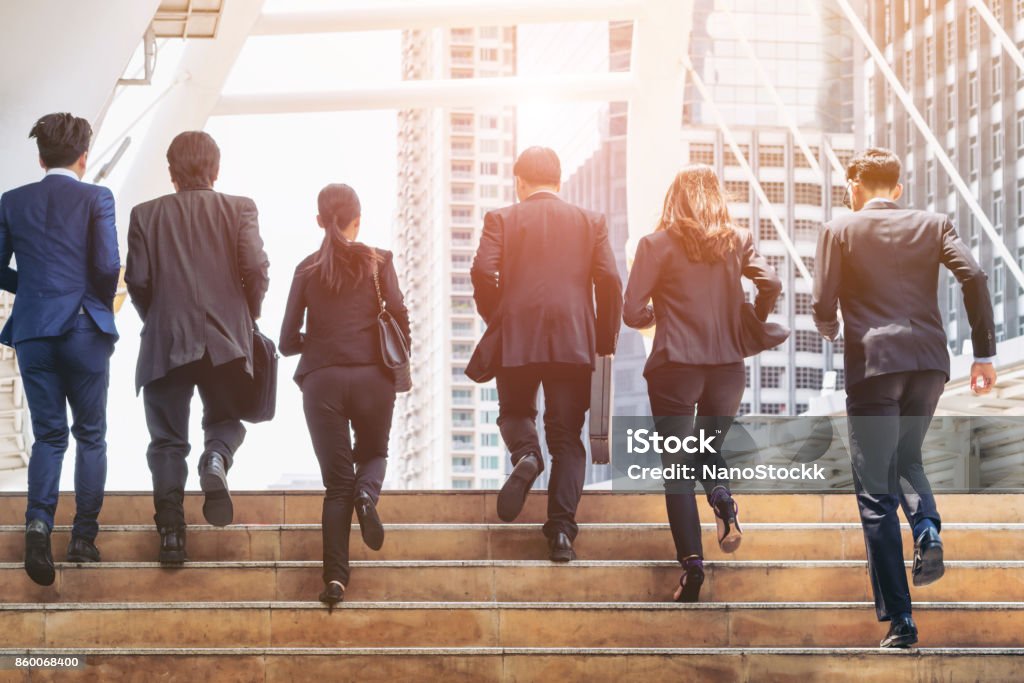 Group of Business People Running in Row Lively business team running in the city. Group of businessmen and businesswomen. Teamwork, togetherness, liveliness, business concept. Business Stock Photo