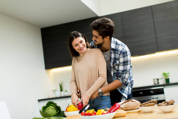 istock Young couple have fun in modern kitchen indoor while preparing vegetables food for lunch 860075846