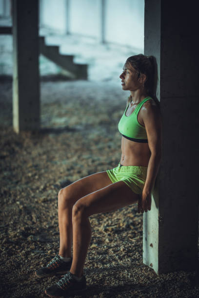 istock Determined woman exercising wall sitting in an old ruin. 860076816