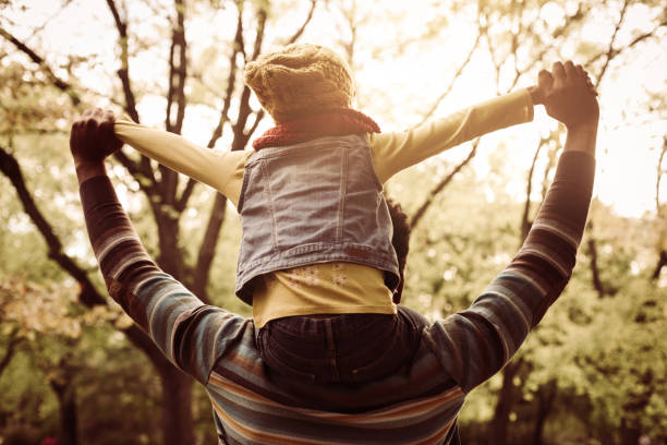 istock African American father carrying his daughter on shoulders. From back. 860076834