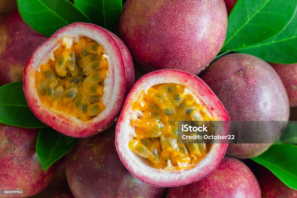Fresh passion fruit on wood table in top view flat lay for background or wallpaper. Ripe passion fruit so delicious sweet and sour. Close up on a half of passion fruit in macro concept.Tropical fruit. Passion Fruit Stock Photo