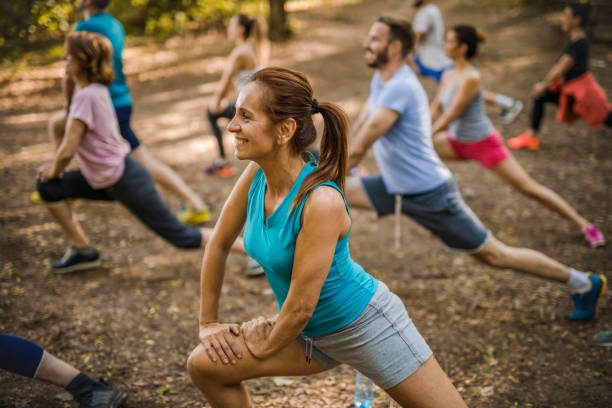 istock Happy woman warming up during exercise class in the park. 860085440