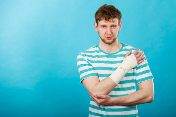 Pain and injury concept. Young man holds bandaged hand. Injured part of body. Medicine and healthcare.