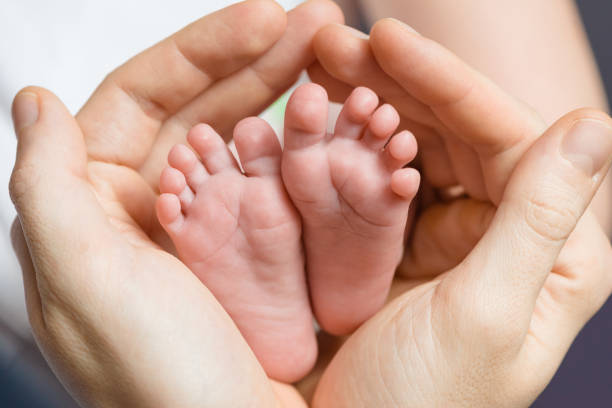 istock Little baby feet in her father hands 860088194