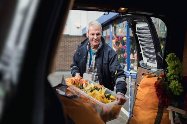 Making A Flower Delivery Events businessman is filling his car with props for a client. working seniors stock pictures, royalty-free photos & images