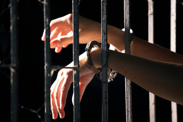 istock hands of prisoner in jail as background. 860093112