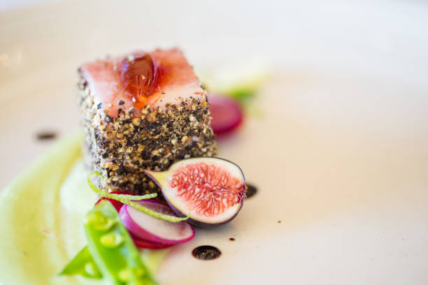 istock Gourmet pork dish covered in crushed black pepper with green figs on the side 860094154