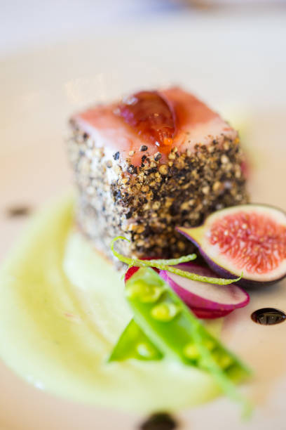 istock Gourmet pork dish covered in crushed black pepper with green figs on the side 860094156