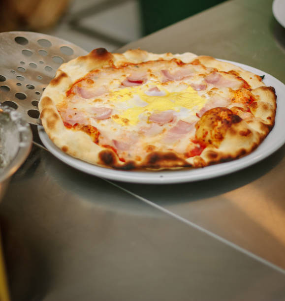 istock Fresh pizza in pizzeria. Chef made pizza and taking it to rhe plate. 860096652