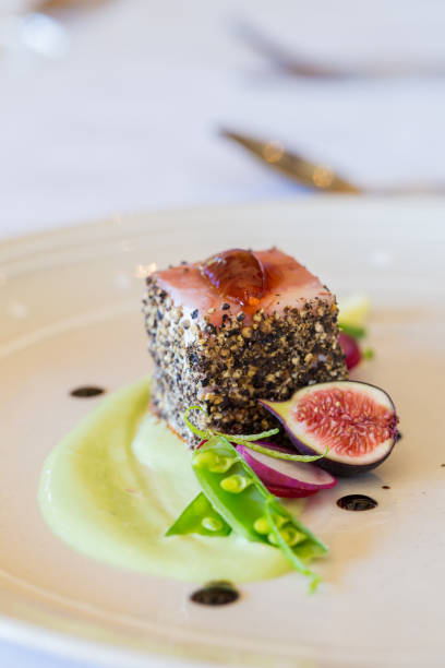 istock Gourmet pork dish covered in crushed black pepper with green figs on the side 860096998