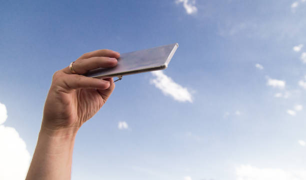 istock phone in hand on a background of clouds 860106156