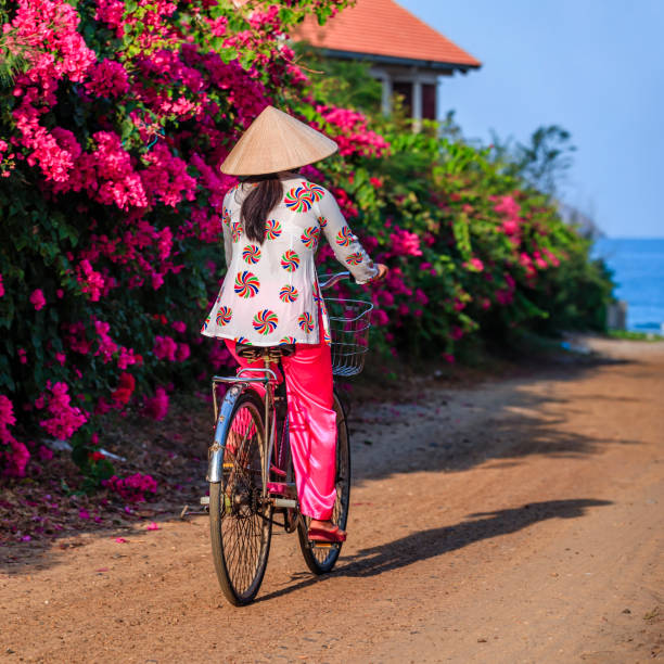 istock Vietnamese woman riding a bicycle, Vietnam 860108876
