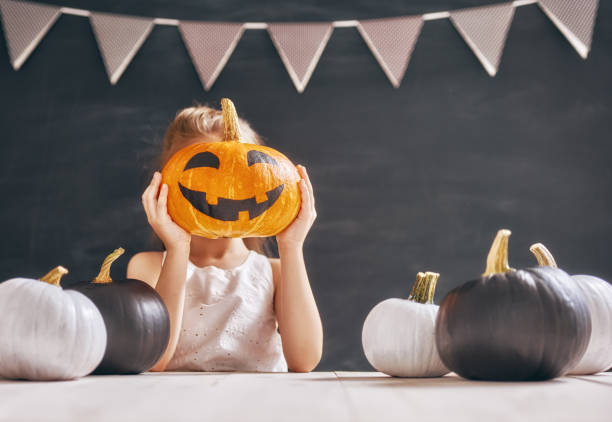 istock girl with pumpkins 860111246
